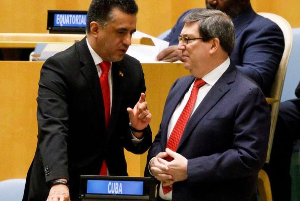 El canciller cubano Bruno Rodríguez conversa con un delegado durante el debate sobre el embargo en la Asamblea General de la ONU (2025).