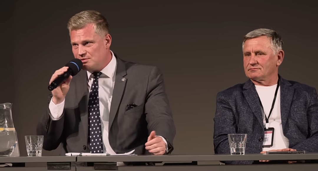 Filip Turek en un panel político del Campamento Conservador 2025 junto a otro participante. Filip Turek saludo nazi. Imagen CC BY 3.0.