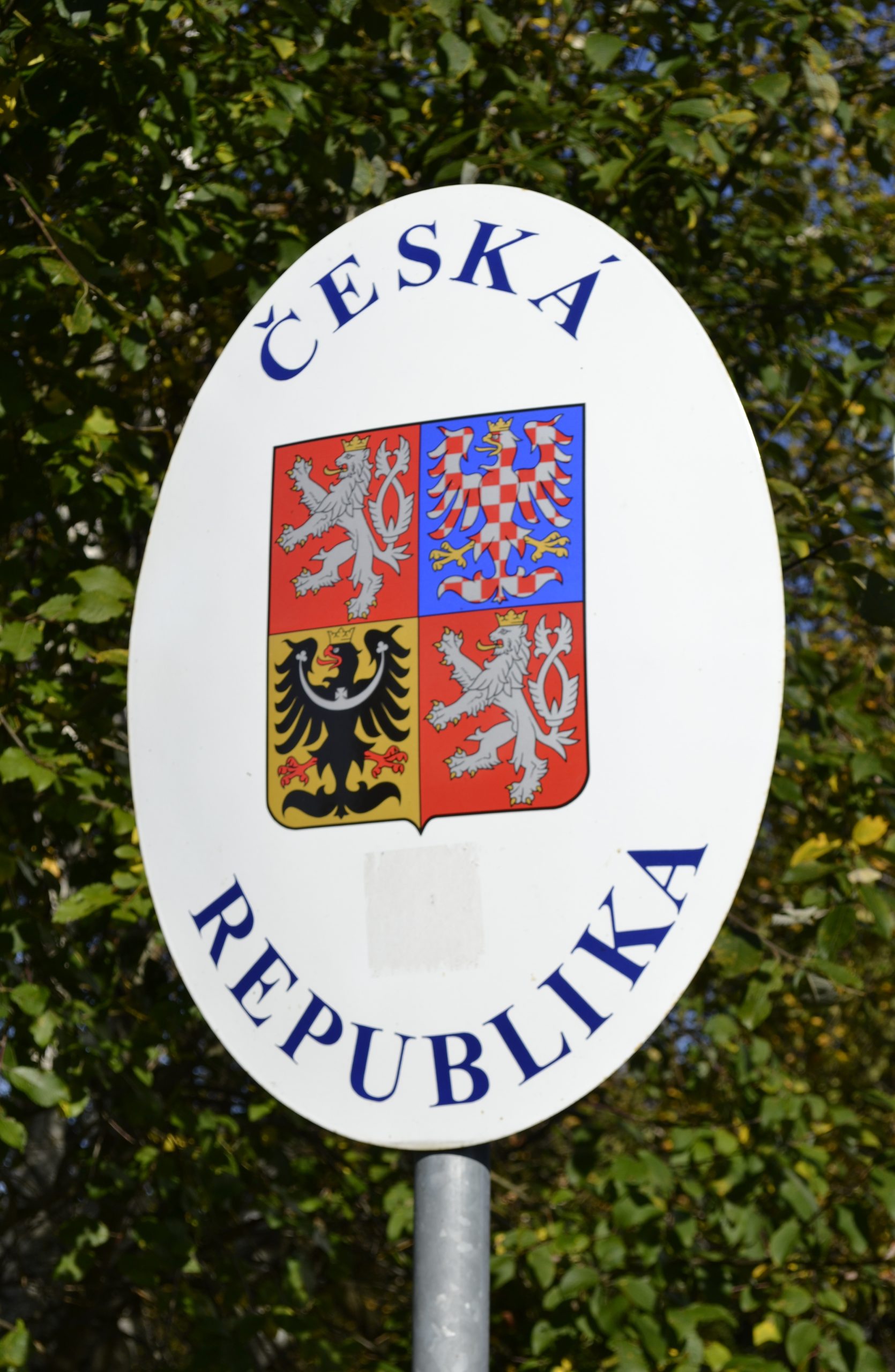 Señal de frontera con el escudo de la República Checa, símbolo de los límites del asilo y la protección en Europa Central.