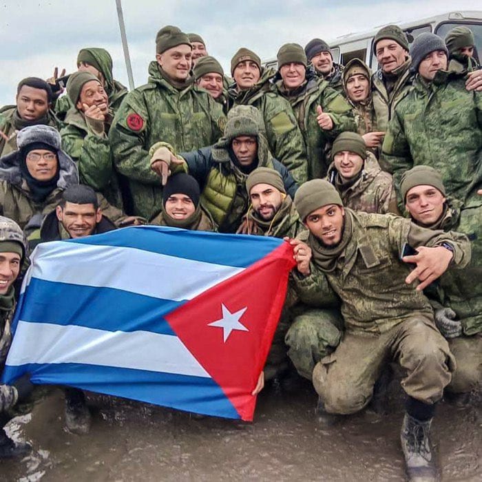 Cubanos reclutados por Rusia posan con uniforme militar y bandera de Cuba; ejemplo del reclutamiento ruso bajo engaño en la guerra de Ucrania.